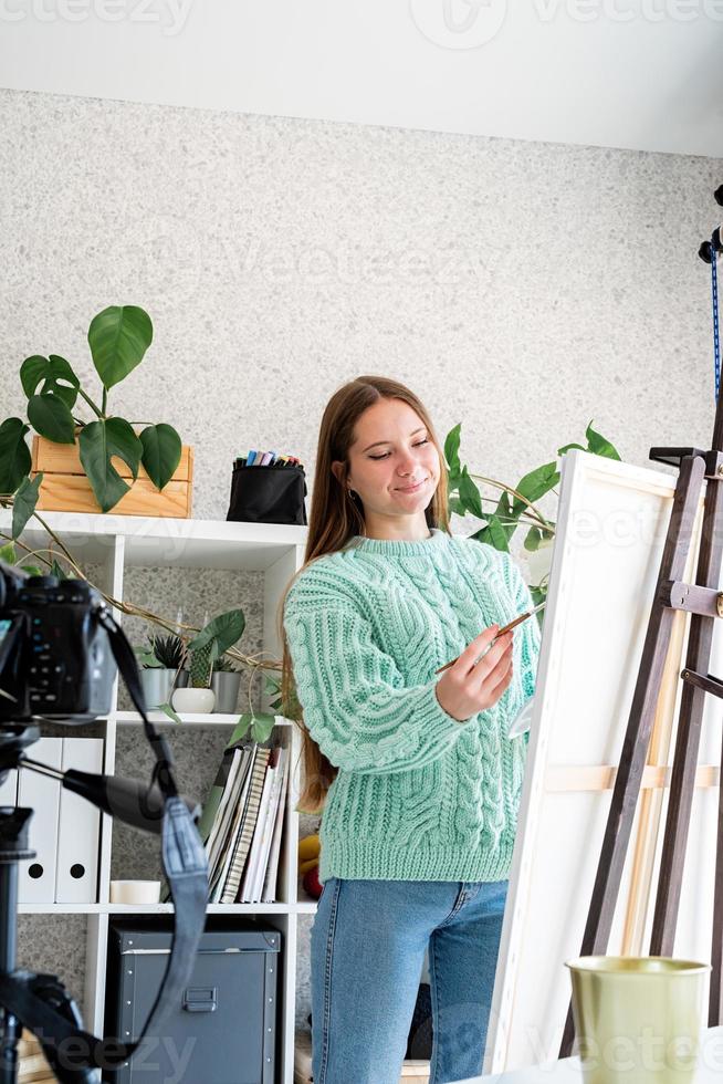 Jeune artiste adolescente tenant une palette de couleurs travaillant dans son studio photo