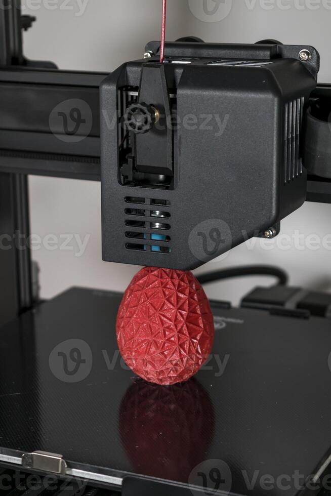 proche en haut de une 3d imprimante impression une rouge polygonal Oeuf photo