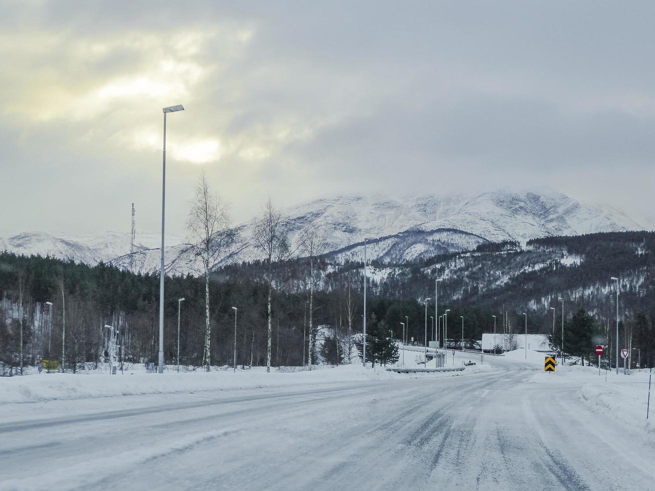 conduire à travers une route blanche enneigée et un paysage en norvège. photo