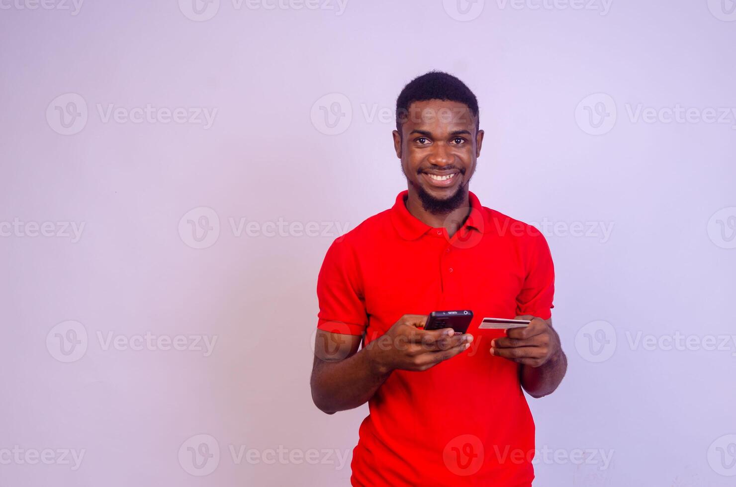 africain homme à la recherche à le sien téléphone et se réjouit comme il a gagné quelque chose photo