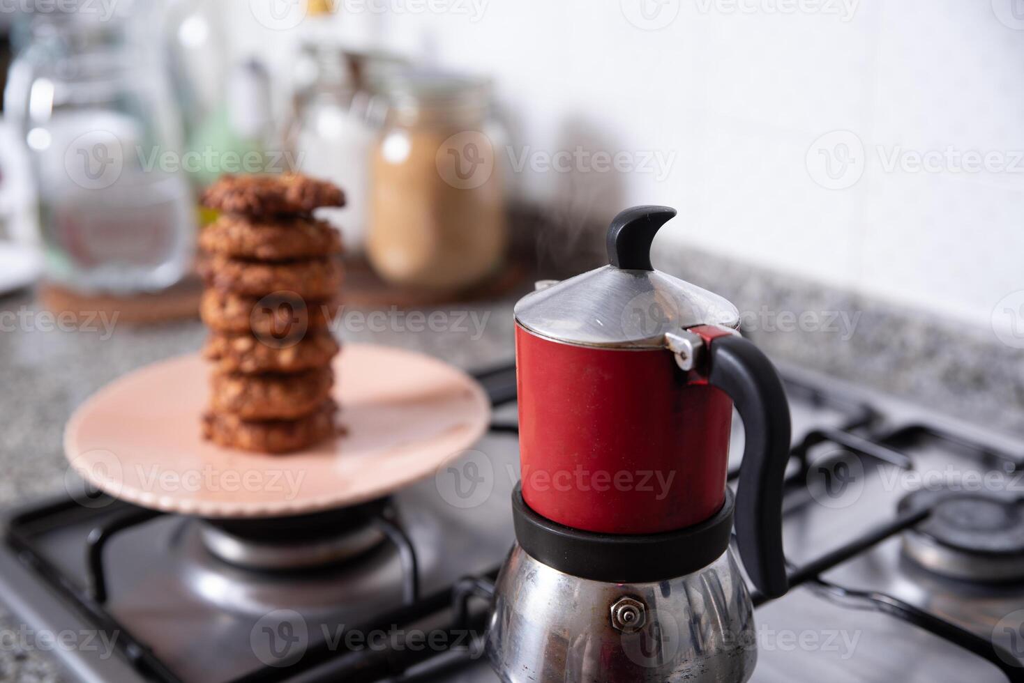 fraîchement préparé biscuits dans le cuisine, servi sur une assiette suivant à une café fabricant. photo