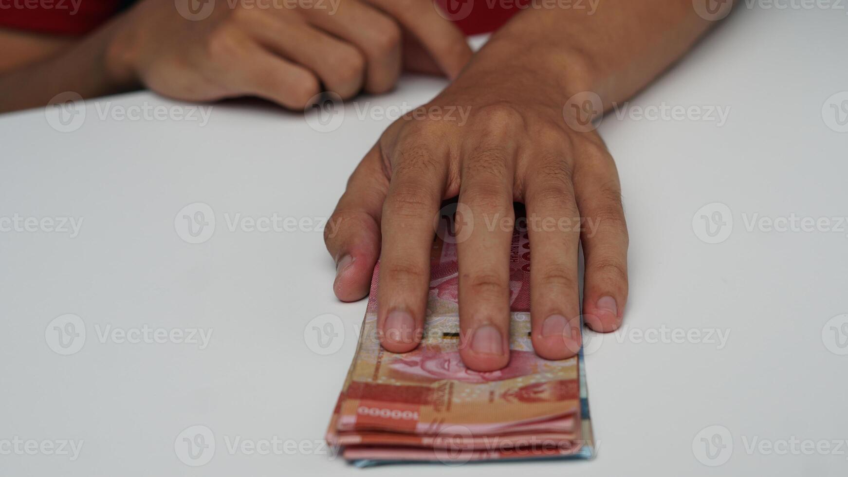 homme main sur indonésien Rupiah billets de banque. financier la gestion concept photo