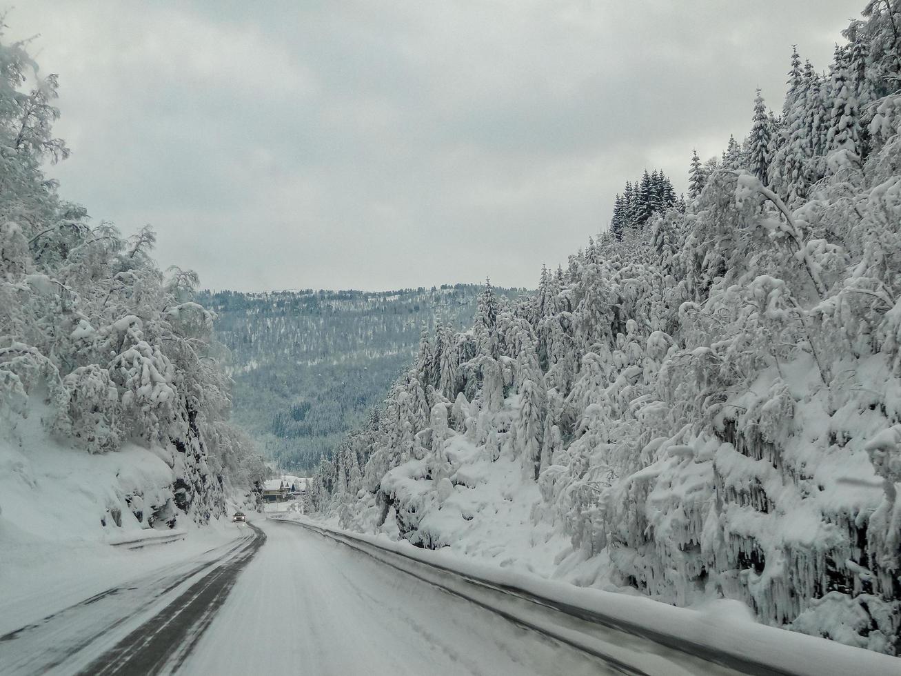 conduire à travers une route enneigée et un paysage en norvège. photo