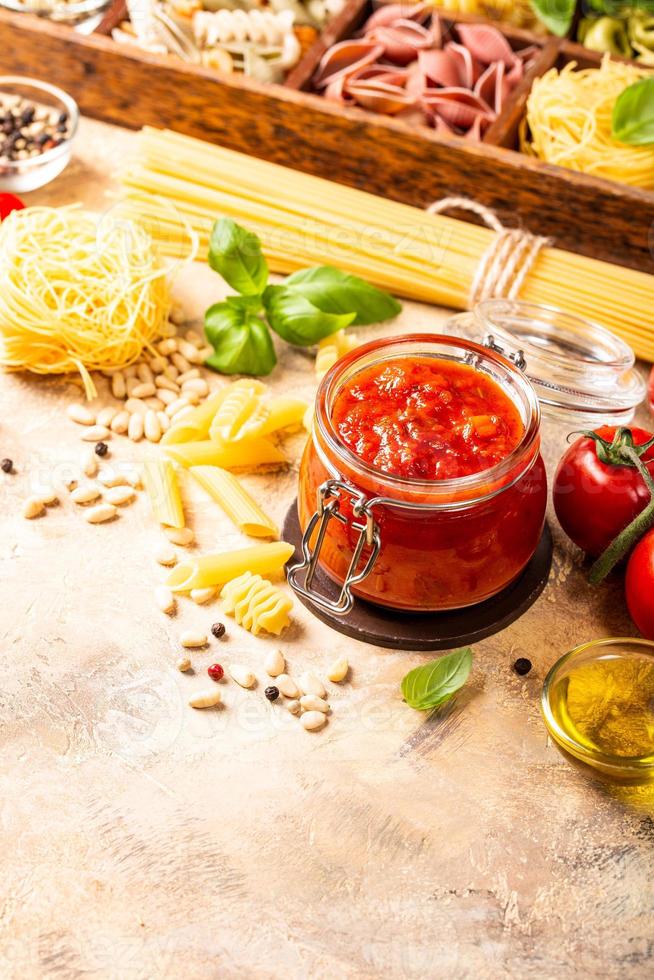 bocal en verre avec des pâtes aux tomates épicées classiques maison ou une sauce à pizza. photo