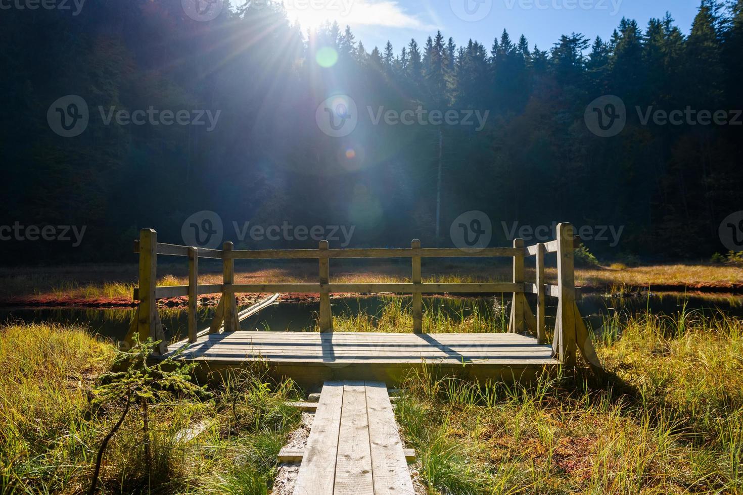 jetée en bois sur un lac dans les montagnes d'automne photo