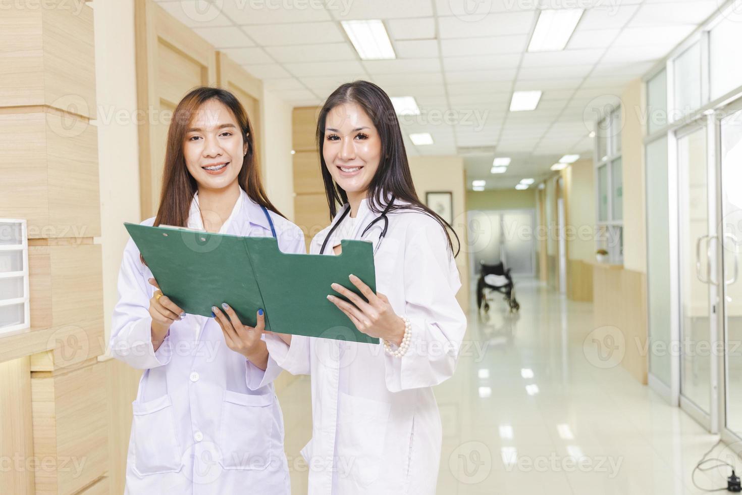 deux femmes médecins ont discuté ensemble d'un cas de patient avec un presse-papiers et se sont tenues à la réception de l'hôpital. photo