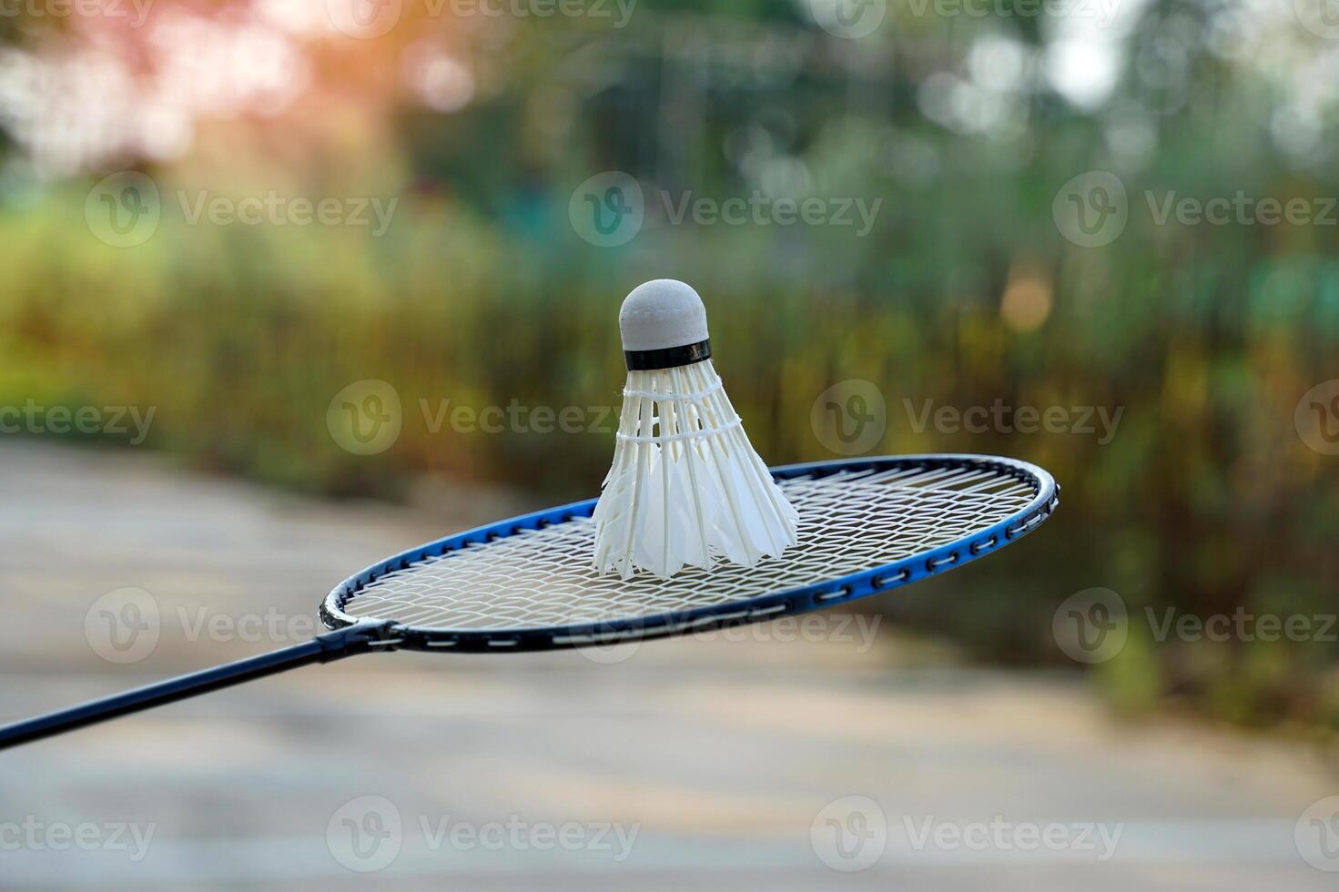 blanc crème badminton volants sur badminton raquettes, flou des arbres arrière-plan, concept pour Extérieur badminton en jouant dans gratuit fois, doux et sélectif se concentrer. photo