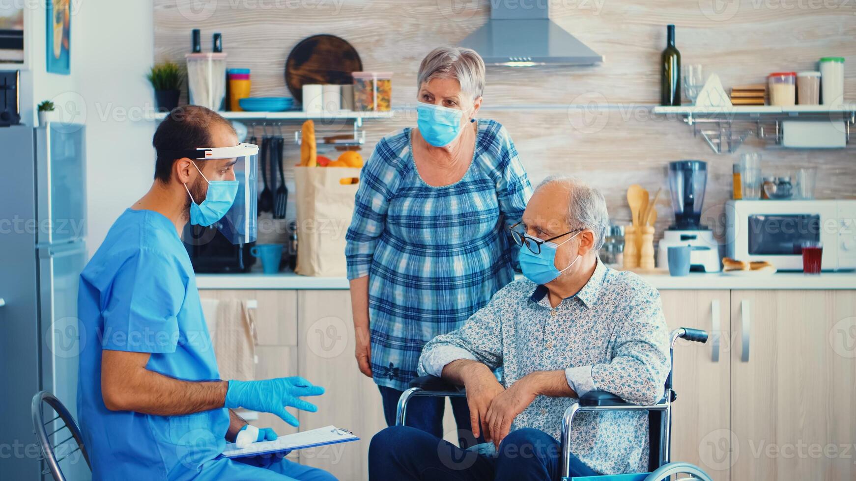 médecin pendant Accueil visite en utilisant infrarouge thermomètre sur désactivée Sénior homme dans fauteuil roulant à vérifier corps température. handicapé personnes âgées la personne avoir recommandation de social ouvrier photo