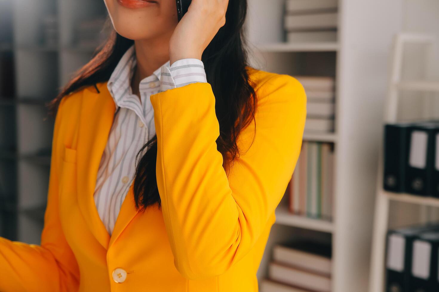 jeune femme d'affaires souriante utilisant un smartphone près d'un ordinateur au bureau, espace de copie photo