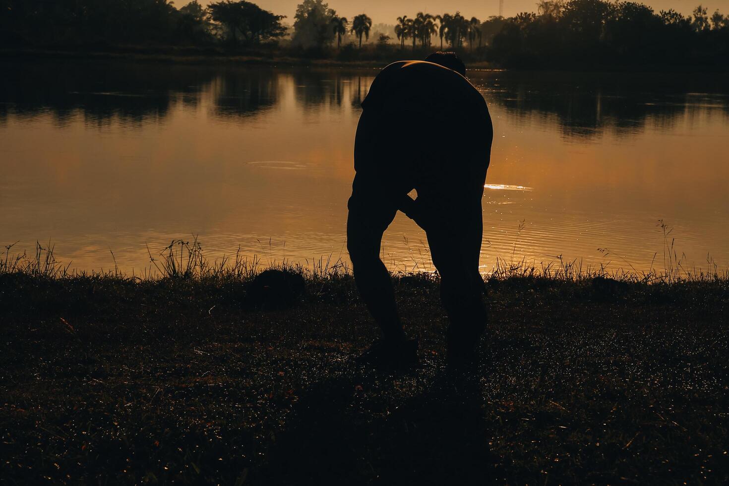 retour vue silhouette de une coureur homme fonctionnement sur le plage à le coucher du soleil avec Soleil dans le Contexte photo