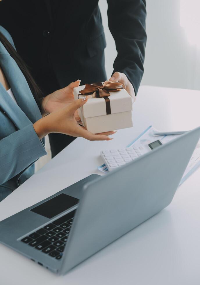 Jeune homme d'affaire donnant le sien collègue présent dans bureau. Jeune homme surprise magnifique femme d'affaires dans bureau. photo