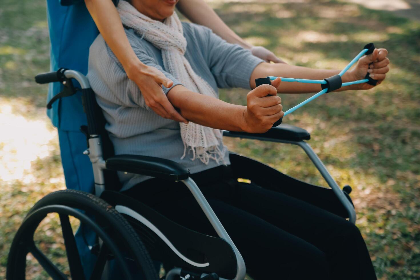 Jeune infirmière ou physiothérapeute dans gommages portion une content retraité vieux femme faire aptitude des exercices avec lumière poids haltères à maison. concept de physiothérapie pour les personnes âgées photo