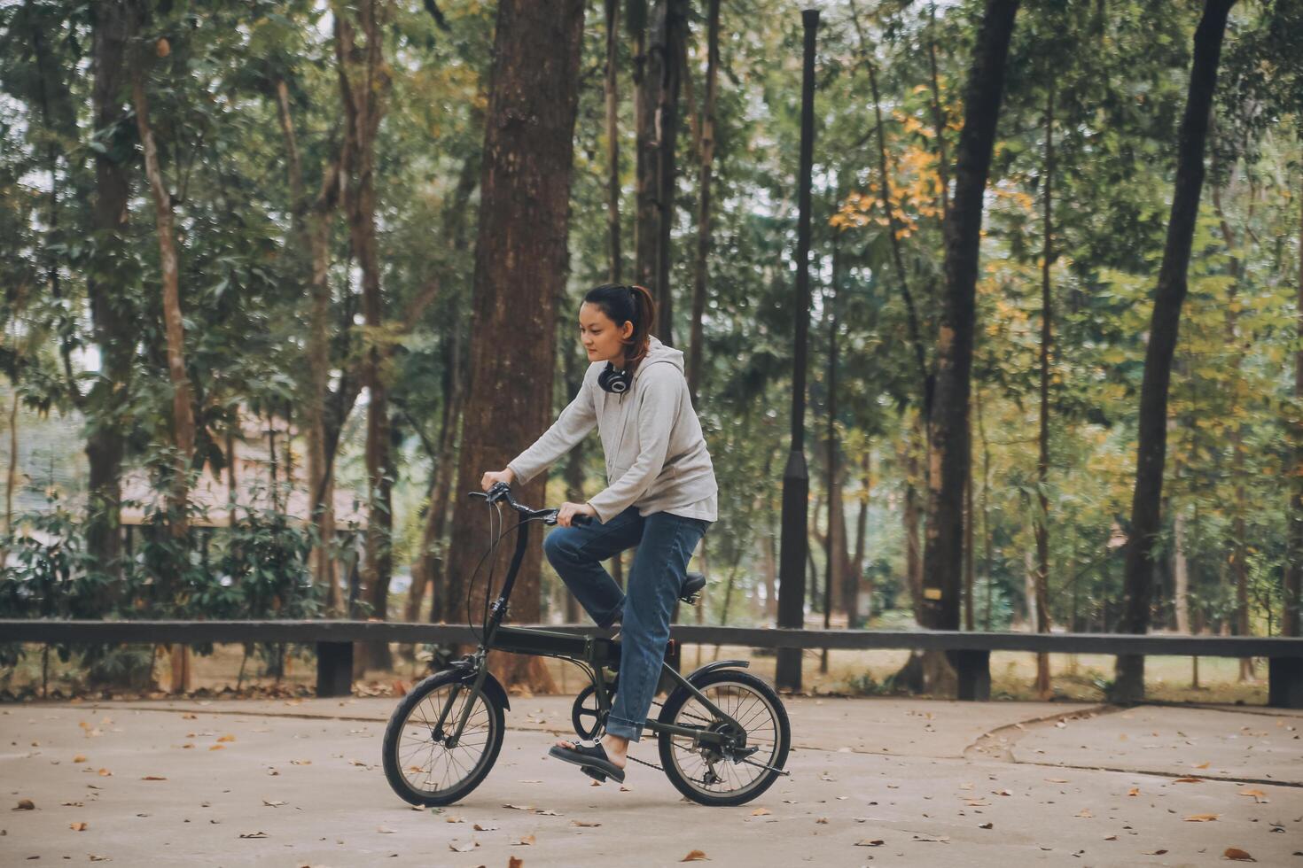 content asiatique Jeune femme marcher et balade vélo dans parc, rue ville sa souriant en utilisant bicyclette de transport, éco amical, gens mode de vie concept. photo