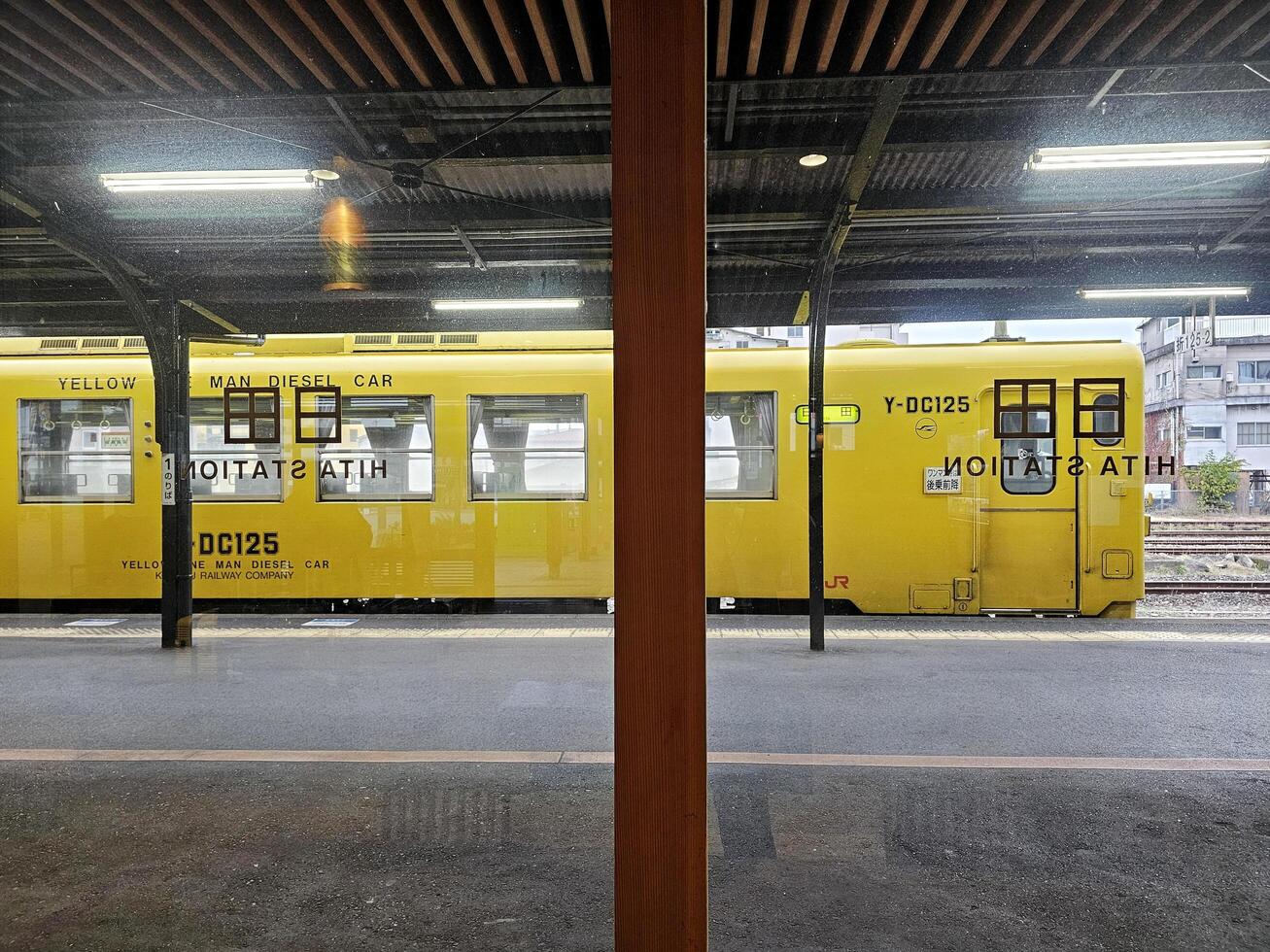 Frapper un, Japon novembre 12, 2023 paysage de Jaune un homme diesel voiture via verre fenêtre à Frapper un station où est une chemin de fer station sur le Kyudai principale ligne opéré par jr Kyushu dans Frapper un. photo