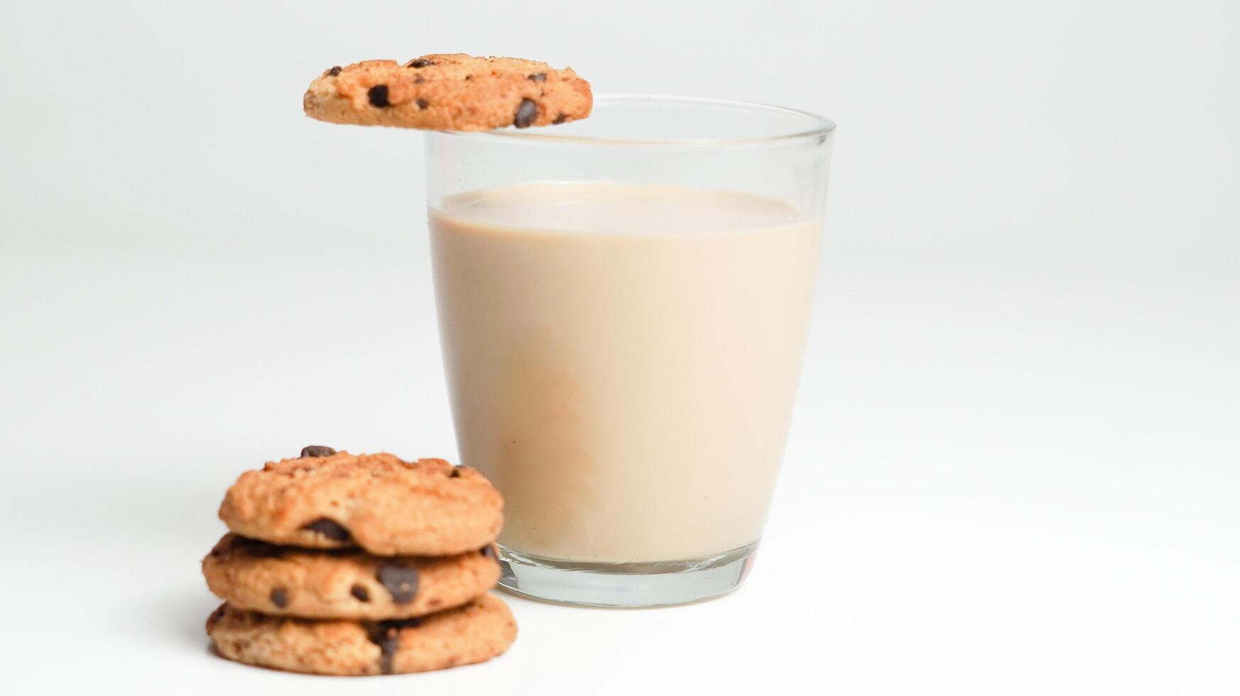 Chocolat puce biscuits et une verre de Lait café sur une blanc Contexte photo