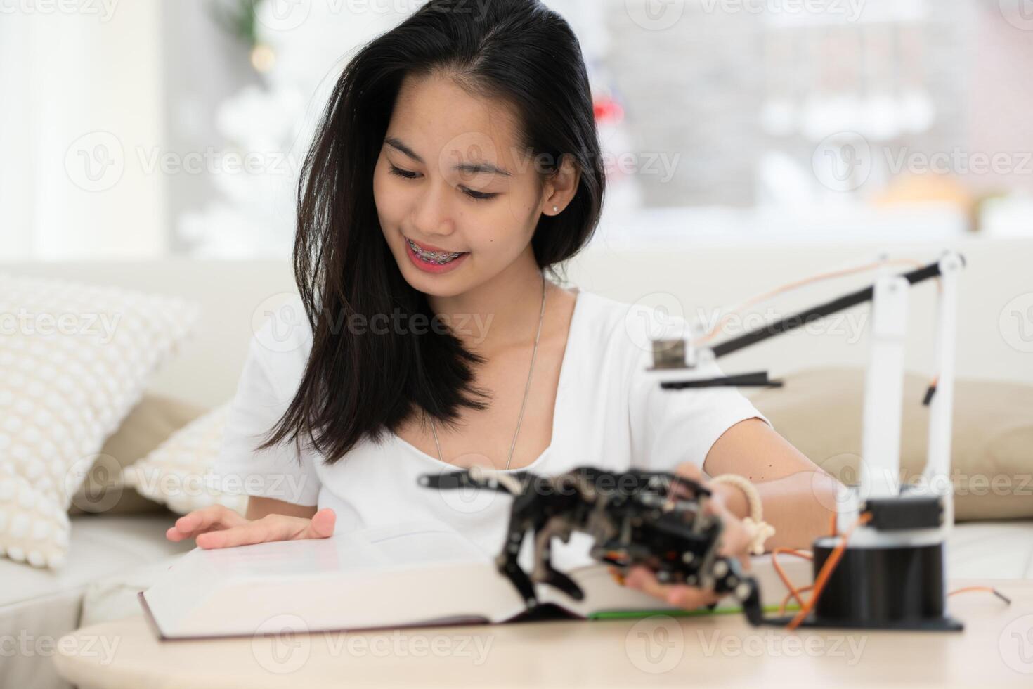 portrait de adolescent les filles élèves en train d'étudier avec main robot modèle dans le vivant pièce photo