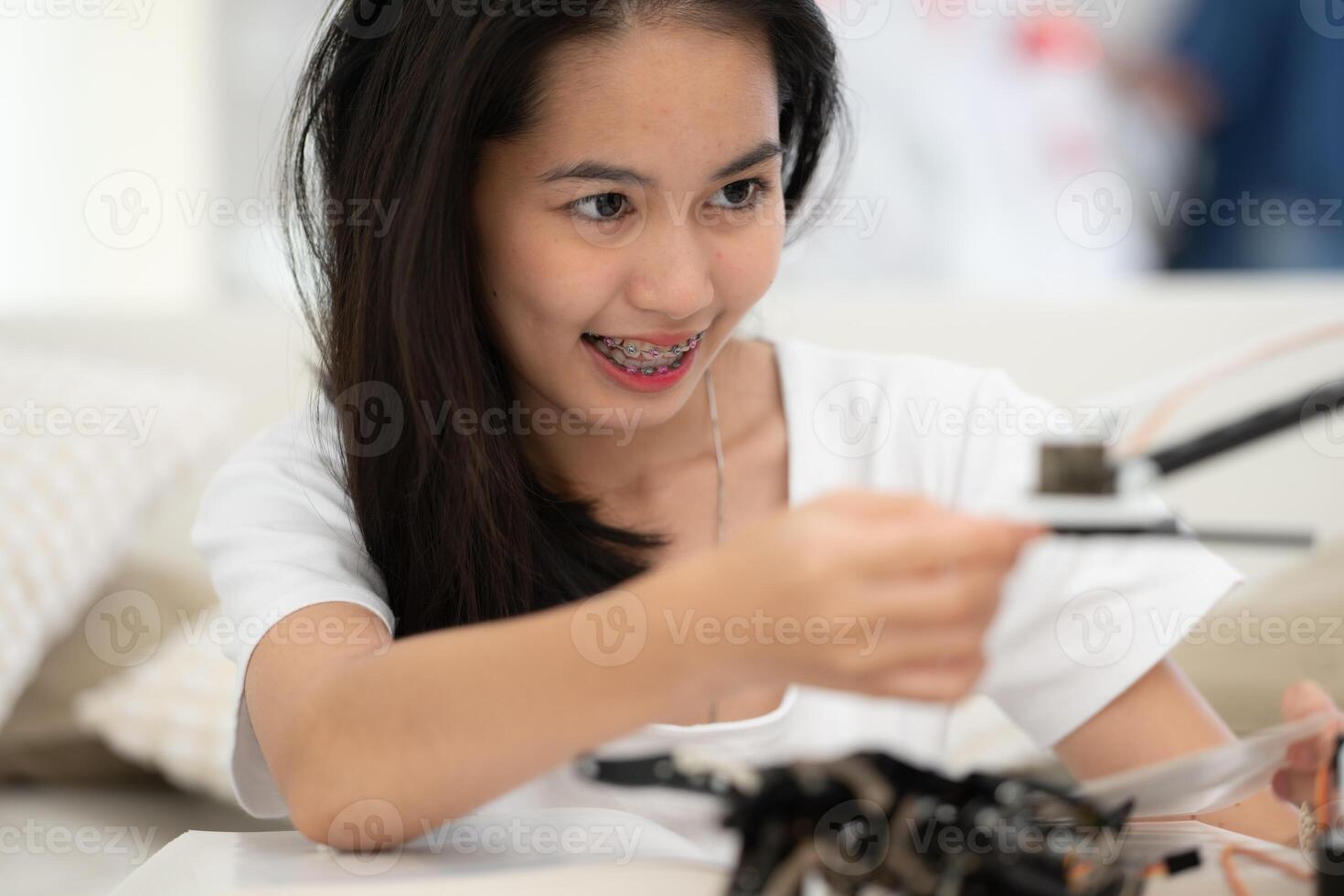 portrait de adolescent les filles élèves en train d'étudier avec main robot modèle dans le vivant pièce photo