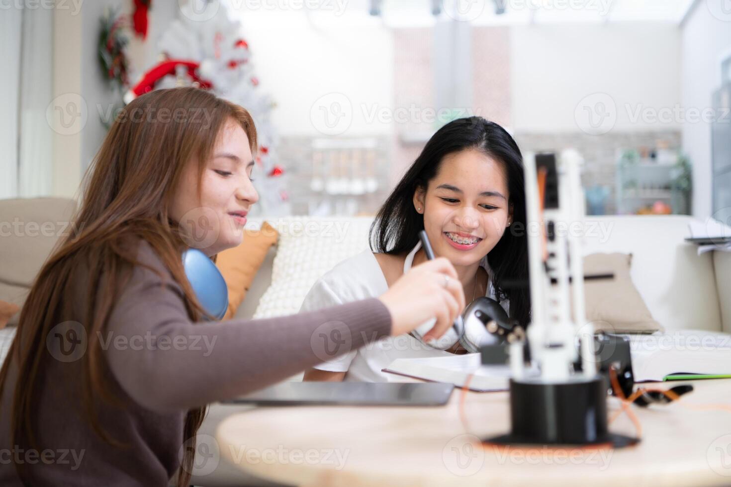 portrait de adolescent les filles élèves en train d'étudier avec robot modèle dans le vivant pièce photo