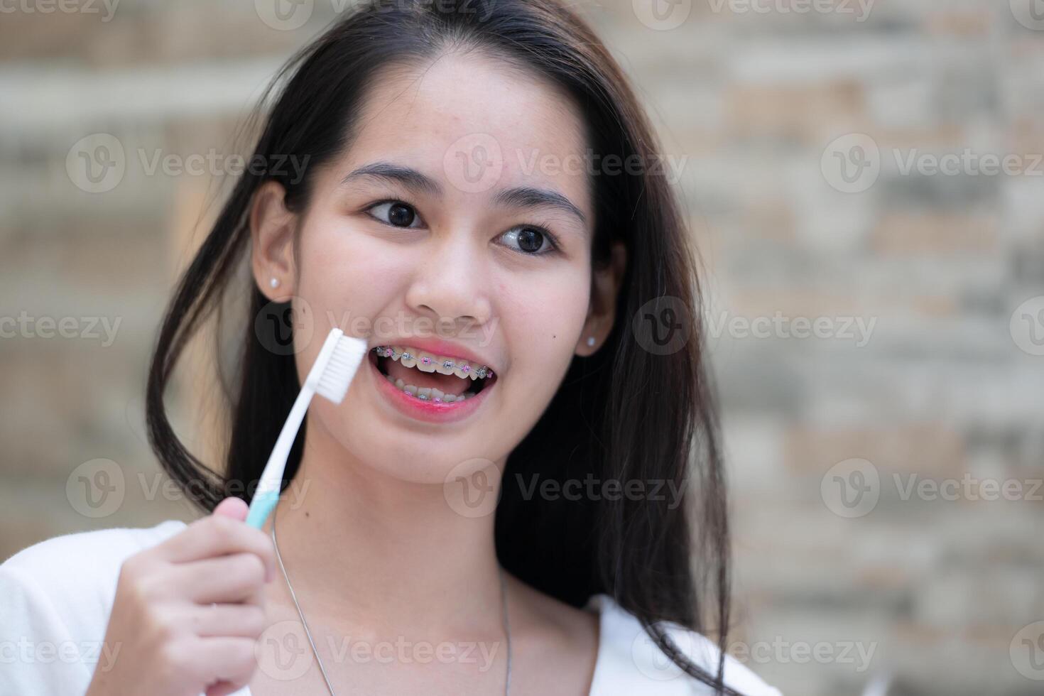 portrait de une Jeune asiatique femme avec un appareil dentaire sur sa les dents photo