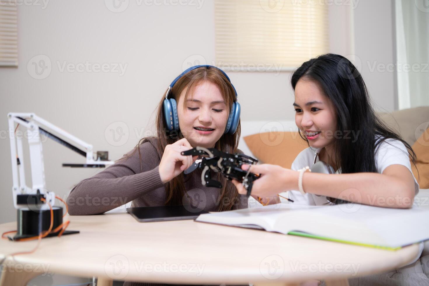 portrait de adolescent les filles élèves en train d'étudier avec robot modèle dans le vivant pièce photo