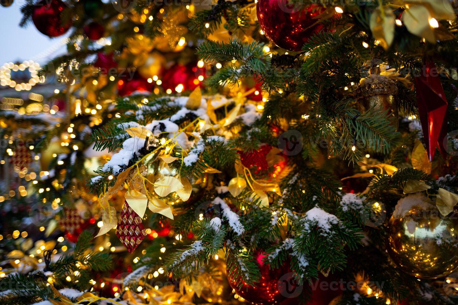 magnifique multicolore jouets sur une Noël arbre contre le Contexte de lumières et neige photo
