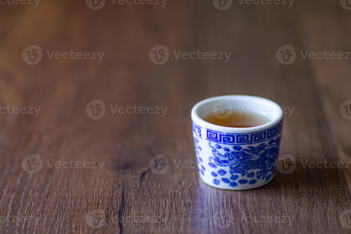 thé l'eau dans une thé tasse dragon modèle sur en bois table photo