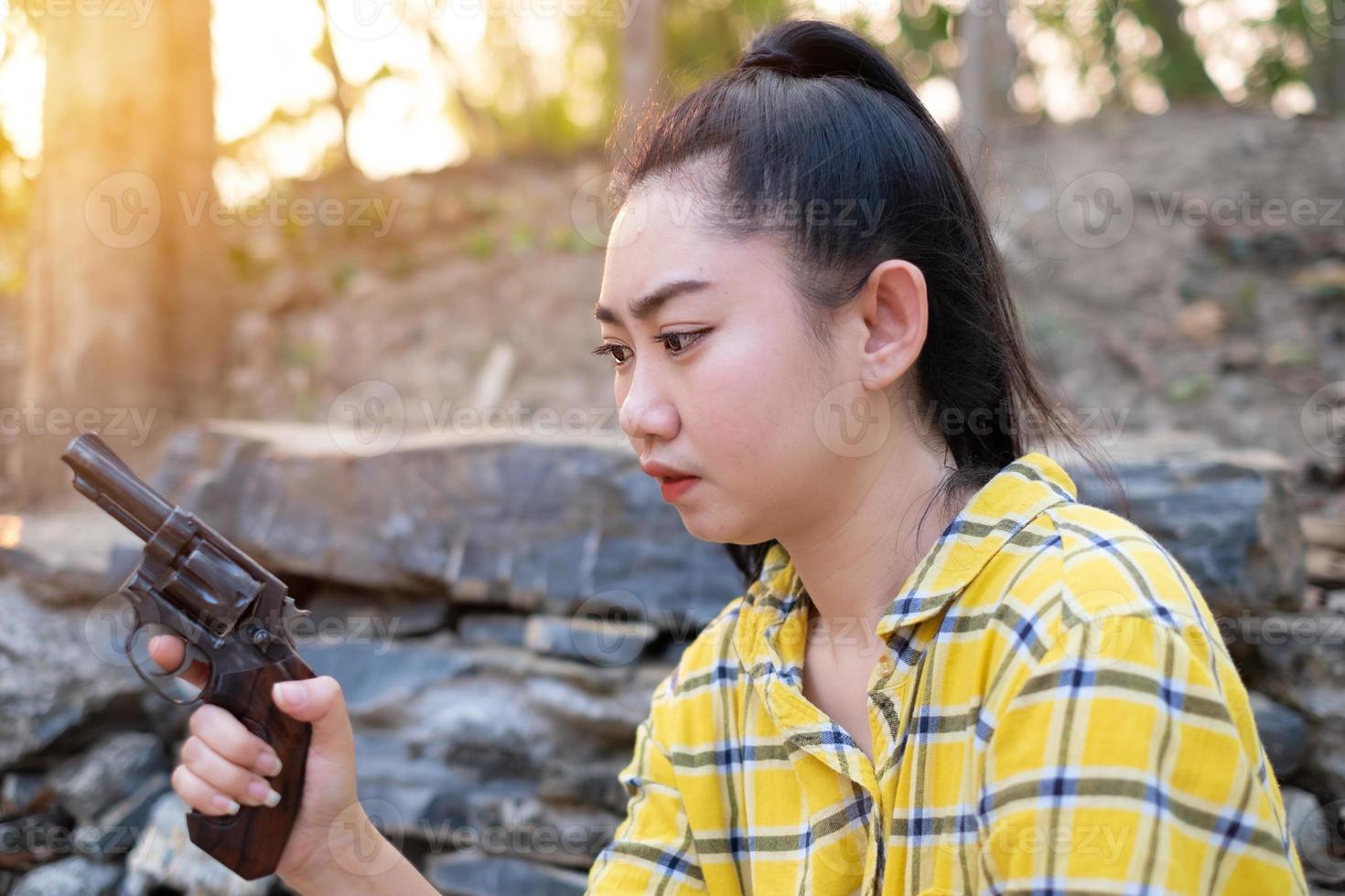 Portrait le fermier asea woman wearing a yellow shirt hand holding old revolver gun dans la ferme, jeune fille avec une arme de poing dans le jardin photo