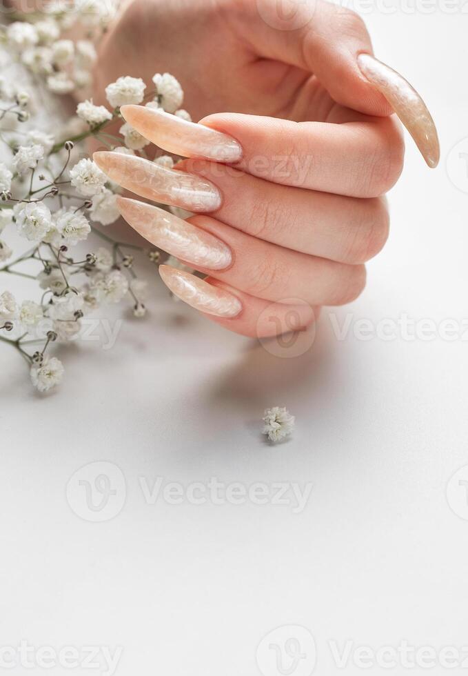 le ongles sont couvert avec perle gel polonais sur blanc Contexte photo