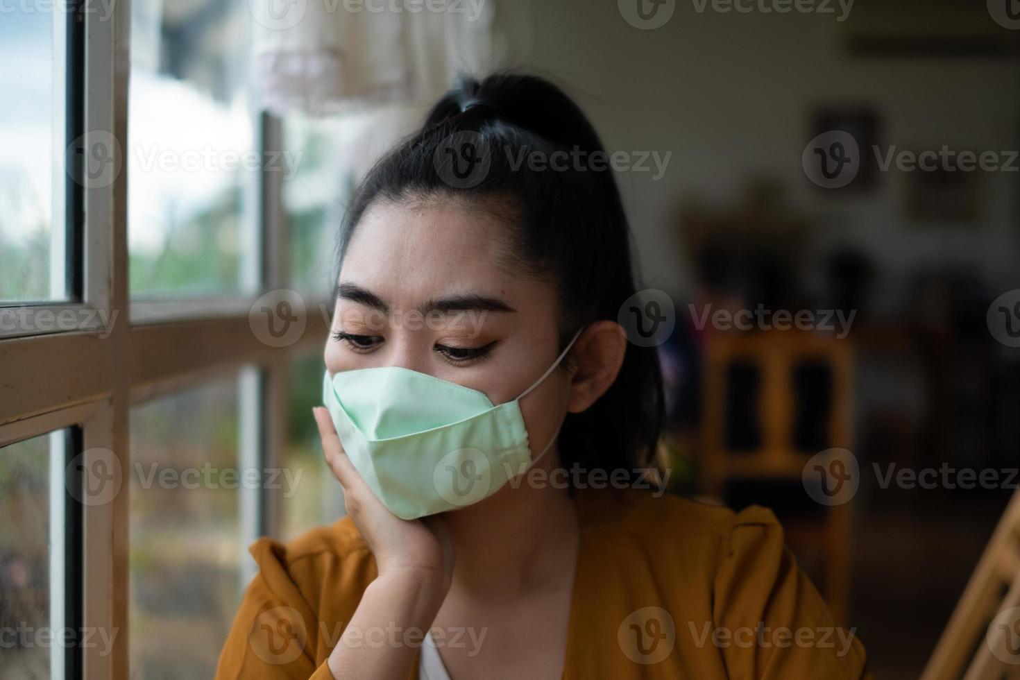 jeune femme asiatique assise et mettant un masque médical pour se protéger des infections virales maladies respiratoires aéroportées au café photo