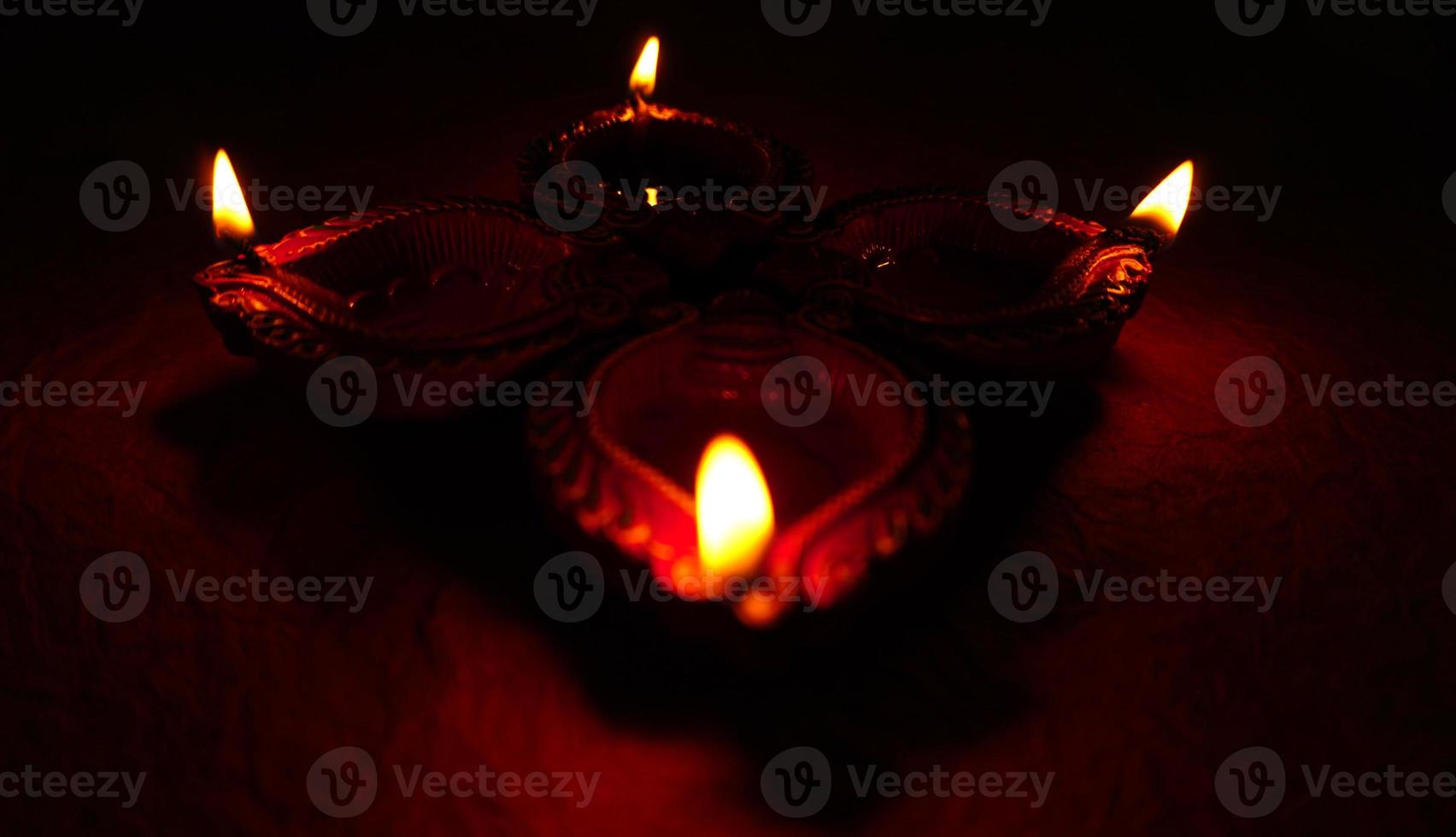 joyeux diwali - lampes diya allumées pendant la célébration de diwali. Des lanternes colorées et décorées sont allumées la nuit à cette occasion avec des rangoli de fleurs, des bonbons et des cadeaux. photo