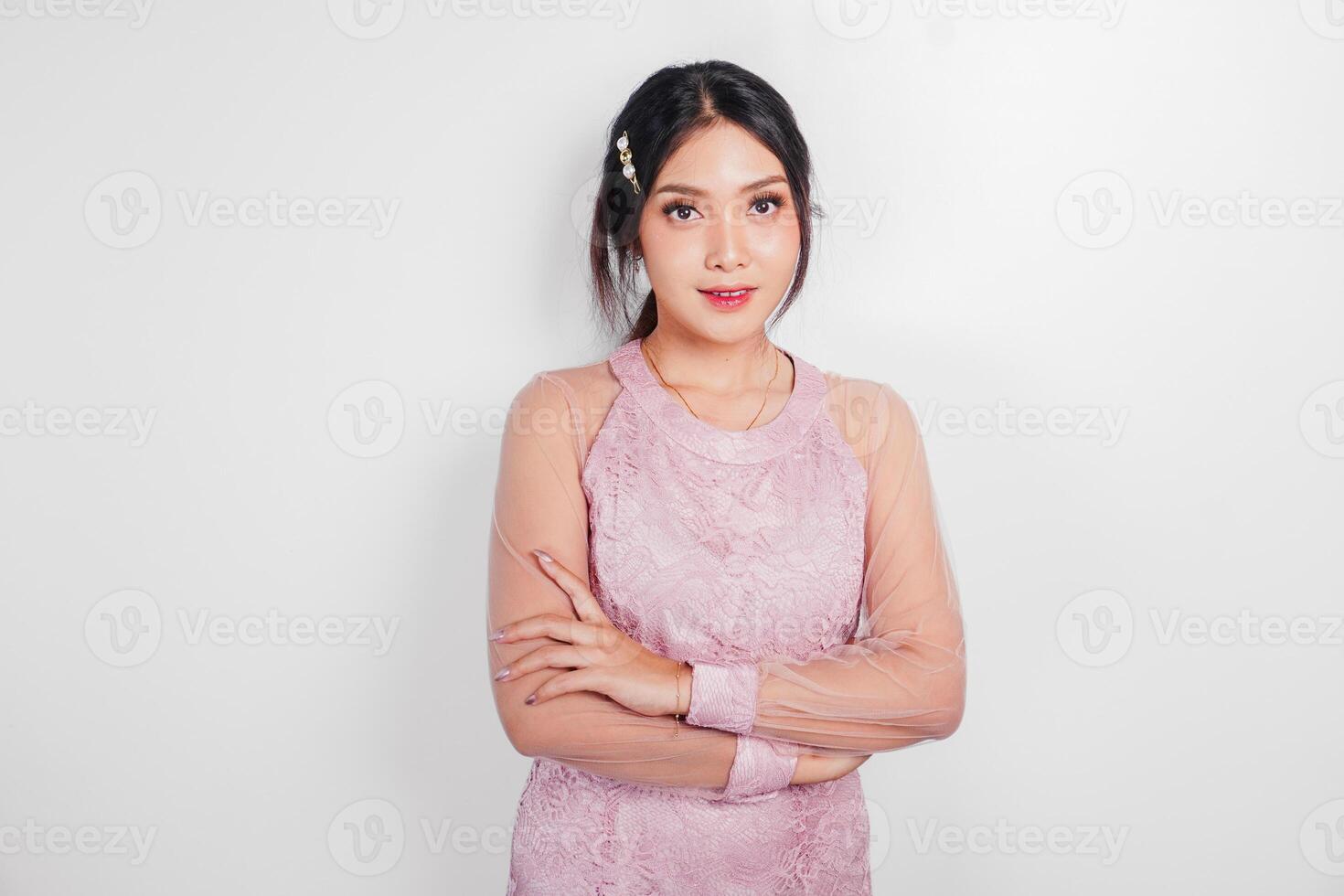 un attrayant asiatique femme portant rose robe est souriant à le caméra, isolé par blanc Contexte. photo