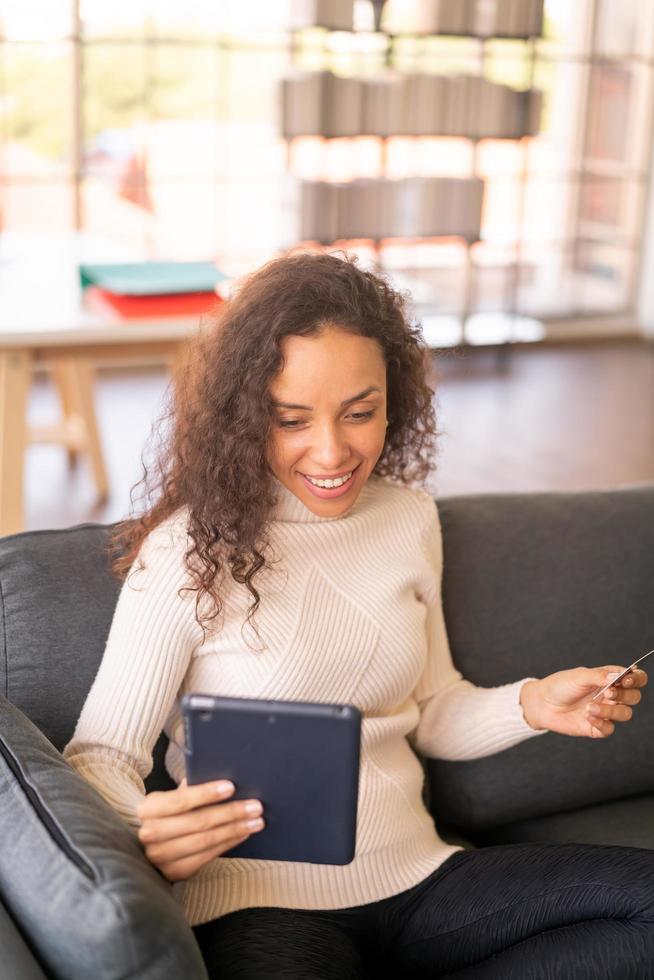 femme latine utilisant une tablette et une main tenant une carte de crédit photo