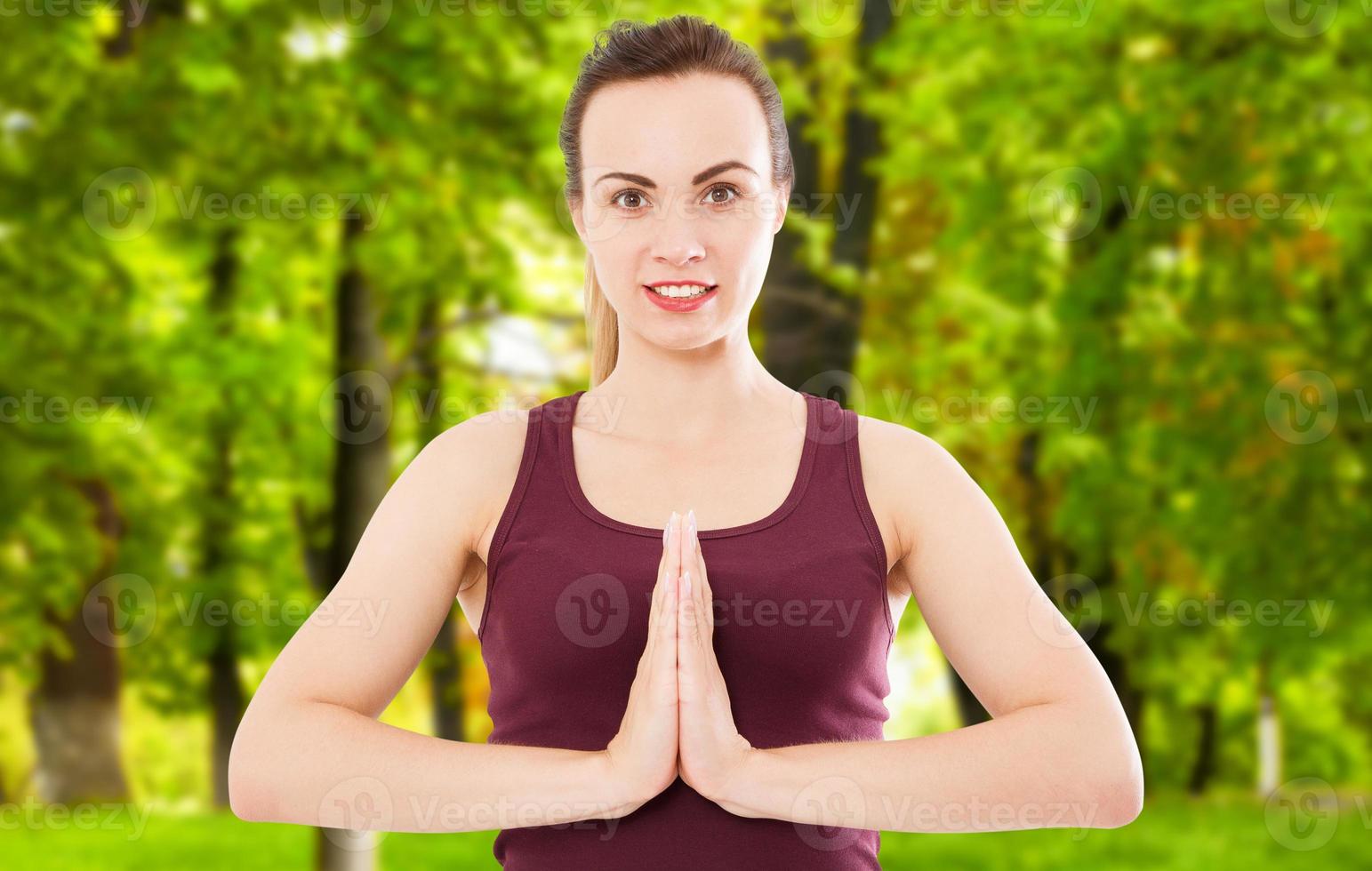 fille active dans la pose de namaste sur un arrière-plan flou du parc photo