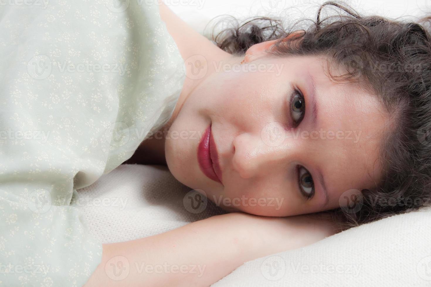 gros plan portrait de beauté d'une belle jeune femme aux yeux verts allongée sur le côté droit. photo