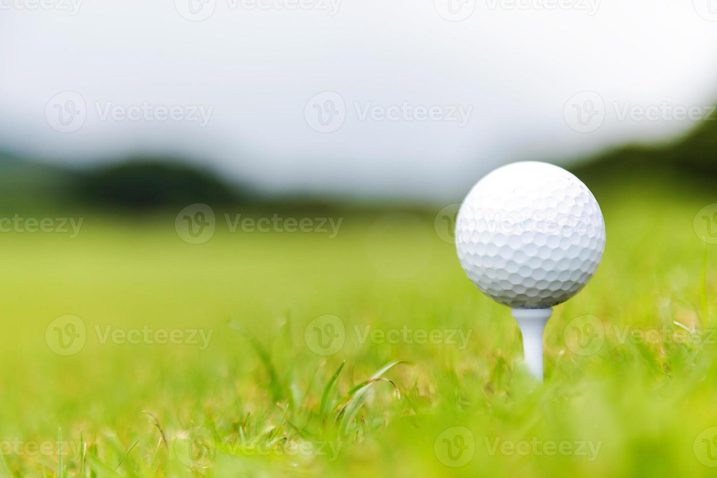 Close up de balle de golf sur le tee sur le parcours de golf photo