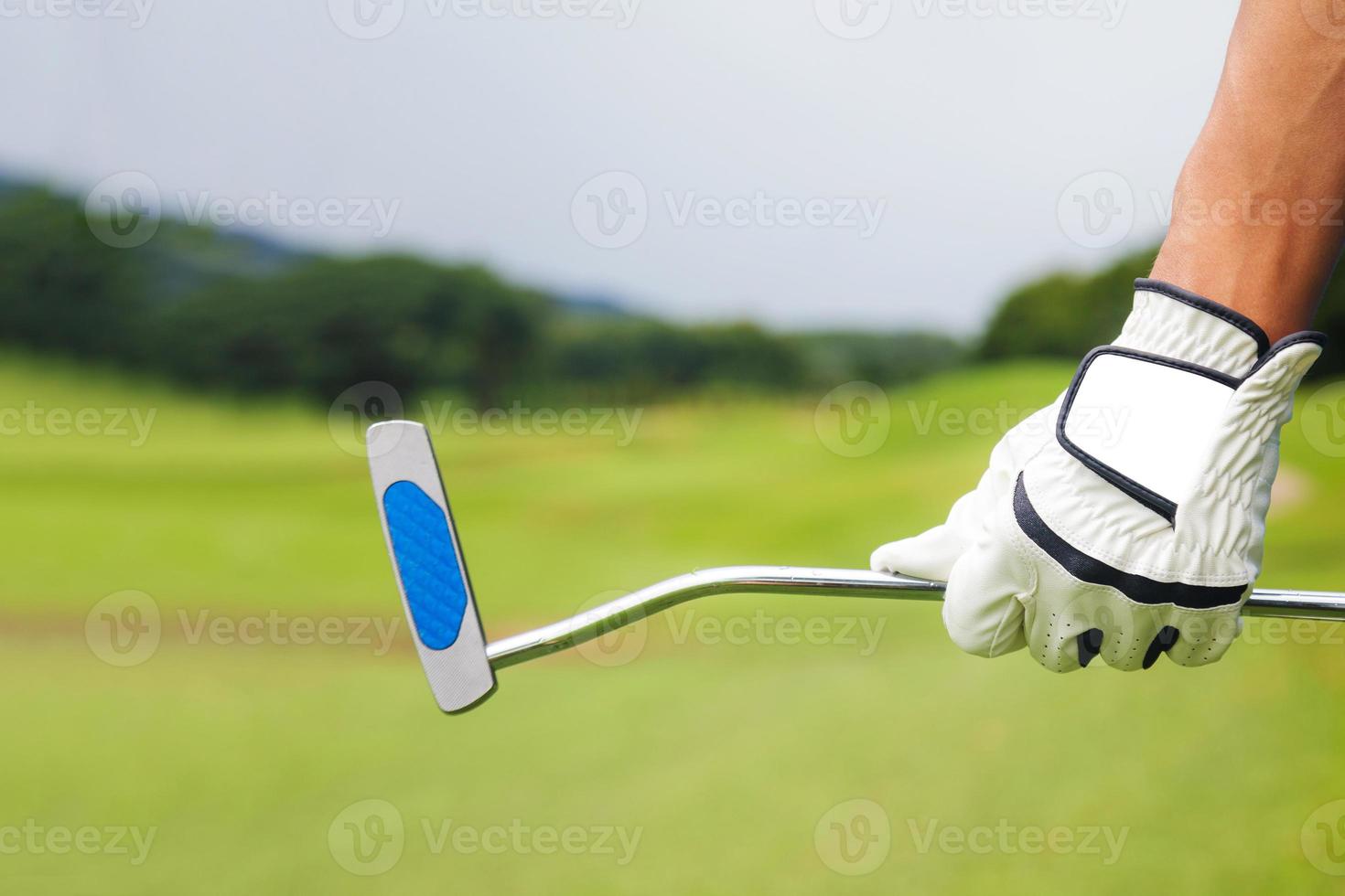 joueur de golf tenant un club de golf sur un terrain de golf photo