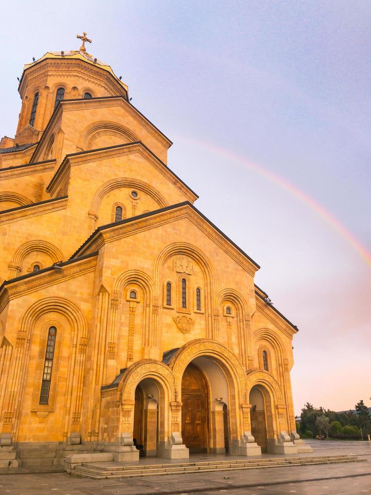 cathédrale sainte trinité de tbilissi avec fond arc-en-ciel photo