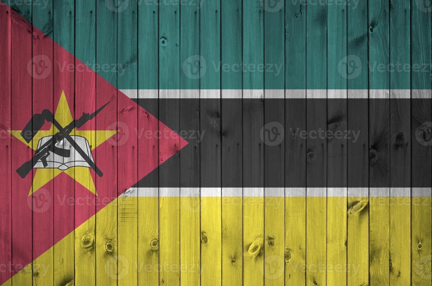 mozambique drapeau représenté dans brillant peindre couleurs sur vieux en bois mur. texturé bannière sur rugueux Contexte photo