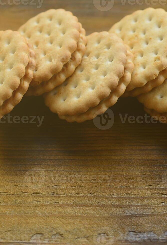 un biscuit sandwich rond fourré à la noix de coco se trouve en grande quantité sur une surface en bois marron. photo de friandises comestibles sur un fond en bois avec espace de copie