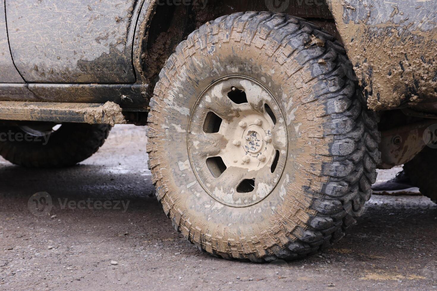 roue fermer dans une campagne paysage avec une boue route. hors route 4x4 suv voiture avec ditry corps après conduire dans boueux route photo