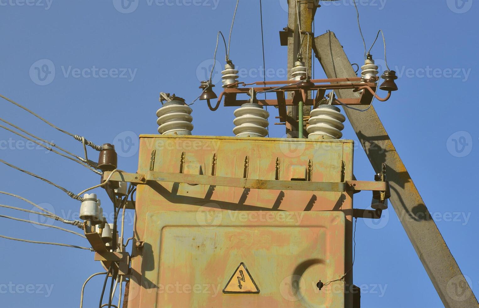 transformateur électrique ancien et obsolète sur fond de ciel bleu sans nuages. dispositif de distribution d'alimentation en énergie haute tension photo