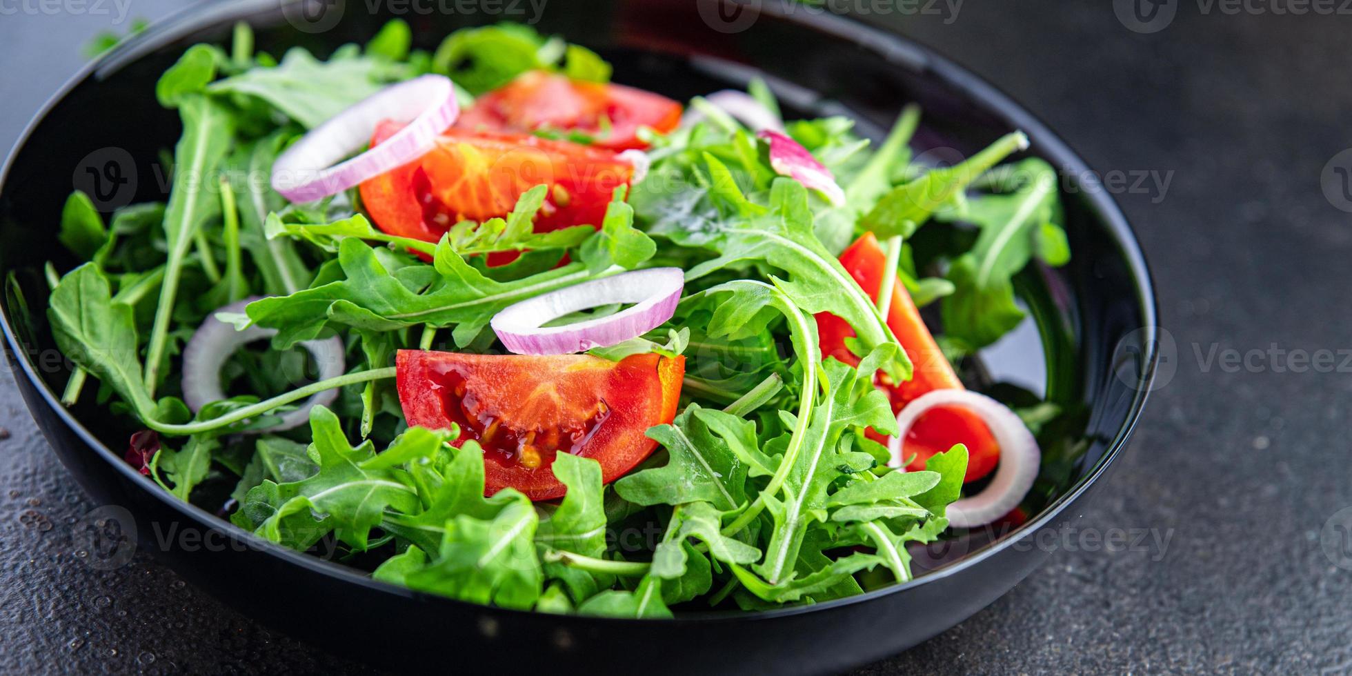 salade de légumes frais roquette, tomate, assiette d'oignon collation repas sur la table copie espace fond de nourriture photo