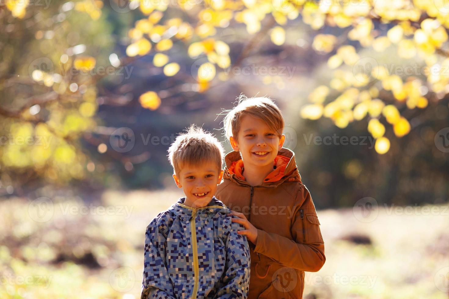 deux garçons frères sur fond de feuillage d'automne photo