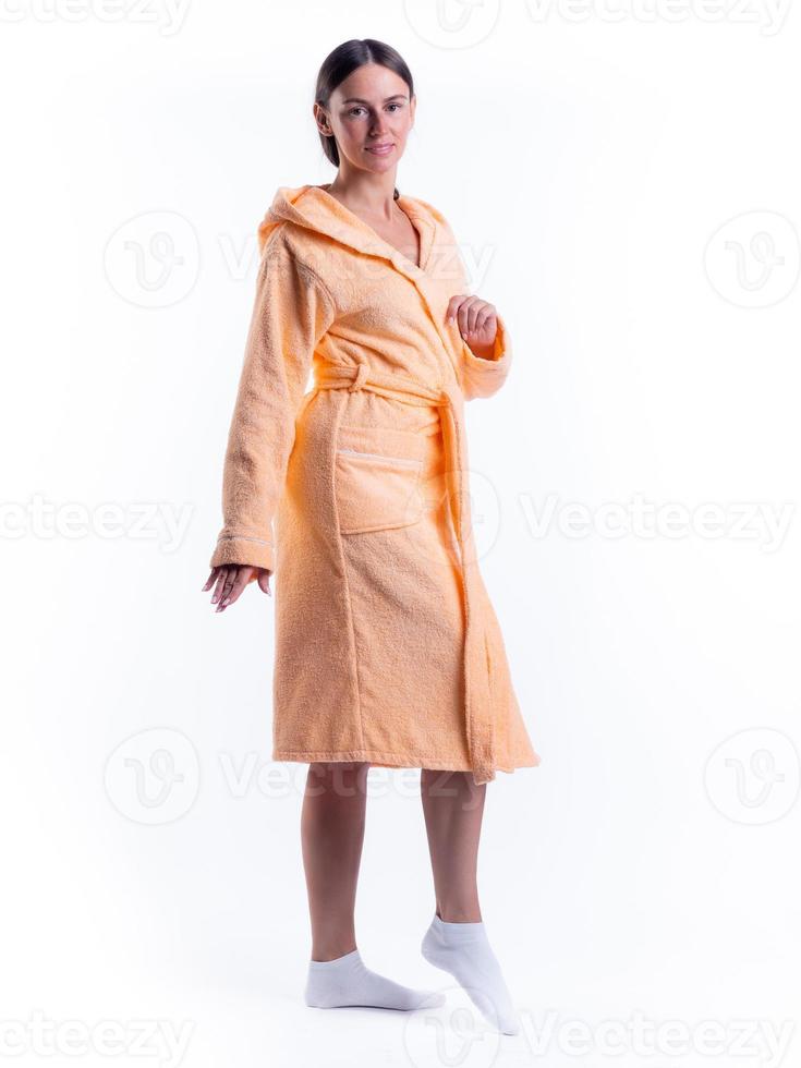 femme en peignoir sur un fond blanc isolé avec un sourire sur son visage. photo