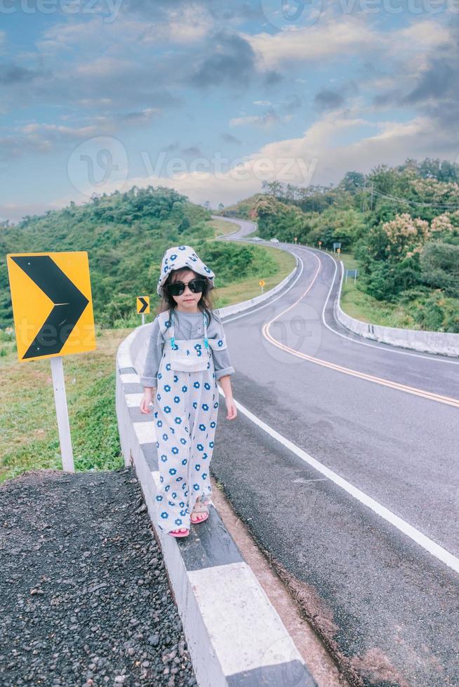 petite fille marchant au bord de la route photo