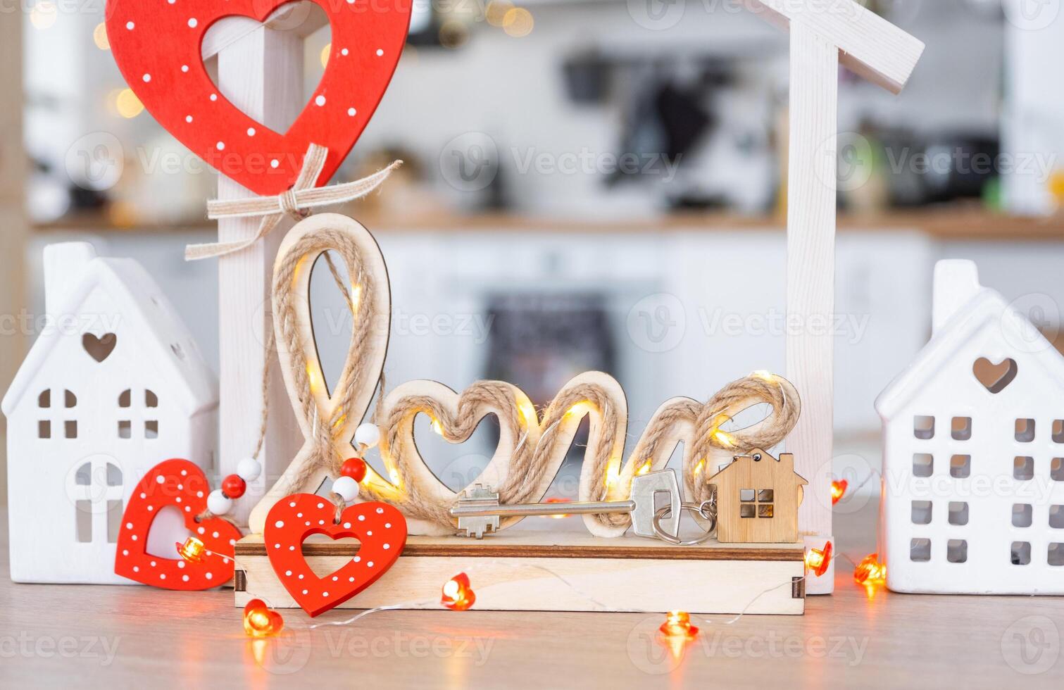 clé à minuscule maison de confortable Accueil avec Valentin décor sur table de cuisine. cadeau pour valentines jour, famille l'amour nid. conception, projet, en mouvement à Nouveau loger, hypothèque, location et achat réel biens photo