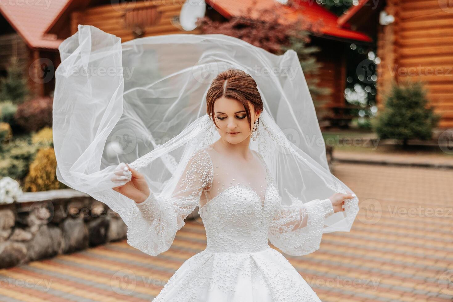 une roux la mariée virevolte sa longue voile contre une Contexte de en bois Maisons. magnifique robe avec longue manches, ouvert bousiller. été mariage photo