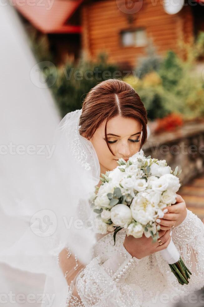 une roux la mariée virevolte sa longue voile contre une Contexte de en bois Maisons. magnifique robe avec longue manches, ouvert bousiller. été mariage photo