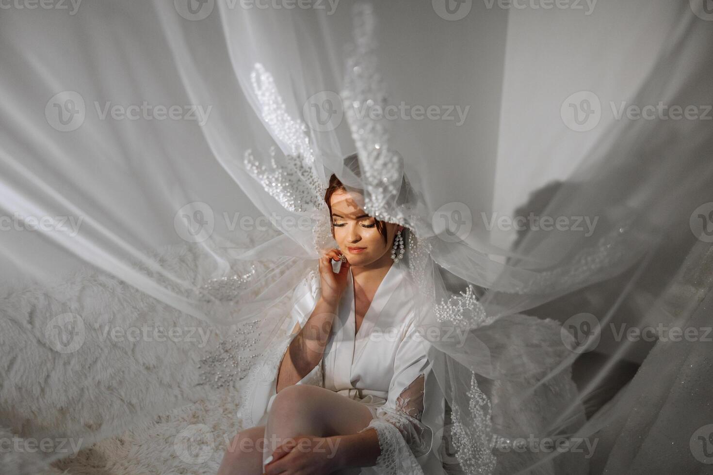 agréable mignonne fille dans une boudoir peignoir. content magnifique la mariée en dessous de voile. mode, beauté, style. Matin de le la mariée. magnifique la mariée avec élégant faire en haut et cheveux style. photo