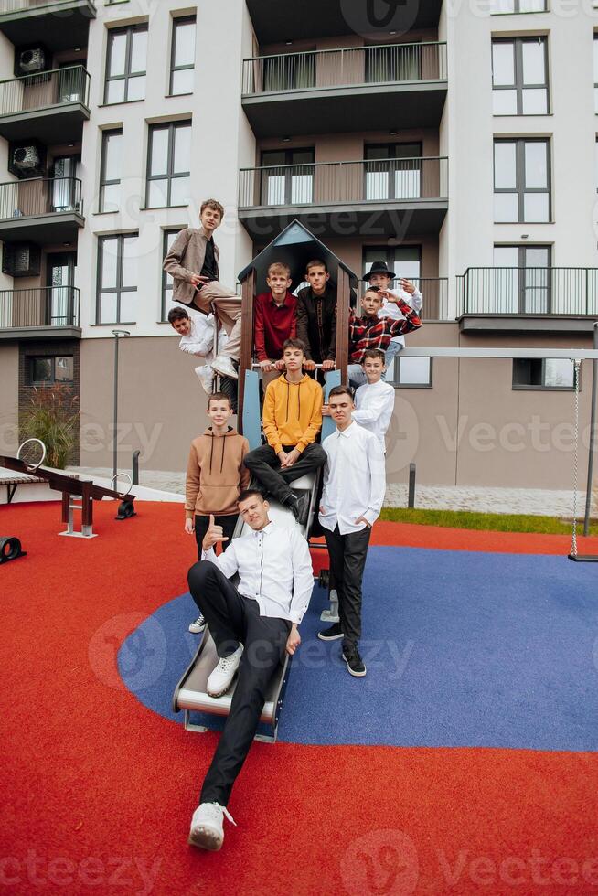 groupe de beaucoup content adolescents habillé dans décontractée vêtements ayant amusement et ayant amusement près collège. concept de amitié, des moments de Bonheur. école relation amicale photo